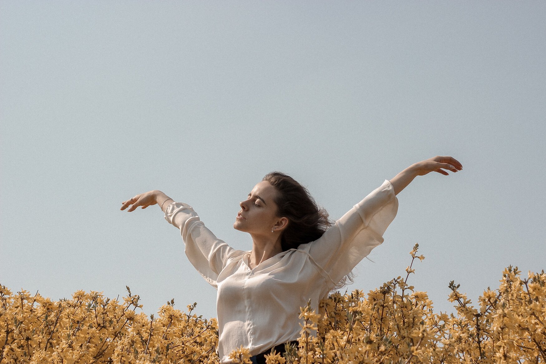 Jeune femme épanouie dans un champ de fleurs Jeune femme épanouie dans un champ de fleurs