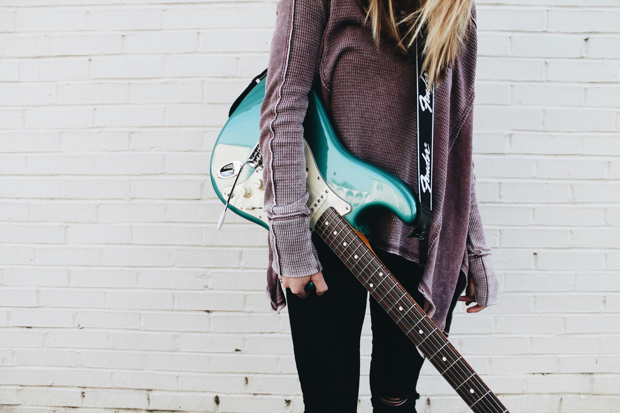 Femme dynamique avec guitare électrique Stratocaster bleue